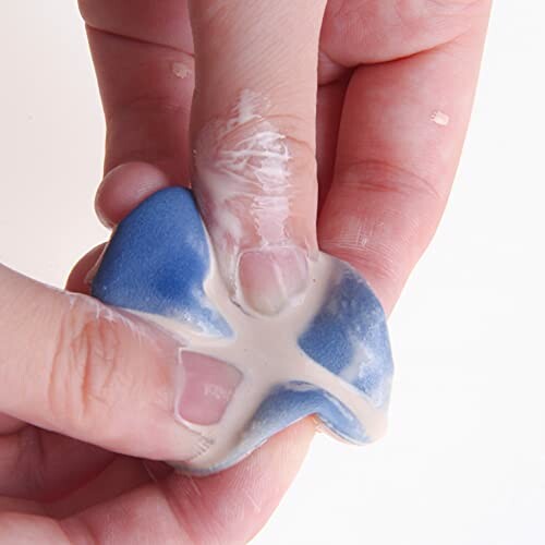 Hands kneading blue and white putty.