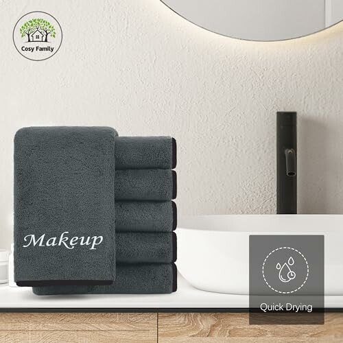 Stack of gray makeup towels in a bathroom setting.